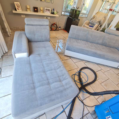 ספות אפורות עם מכונת ניקוי כחולה על רצפה