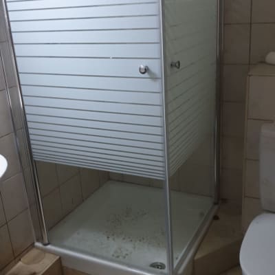 מקלחון זכוכית עם דלתות הזזה, רצפה מלוכלכת