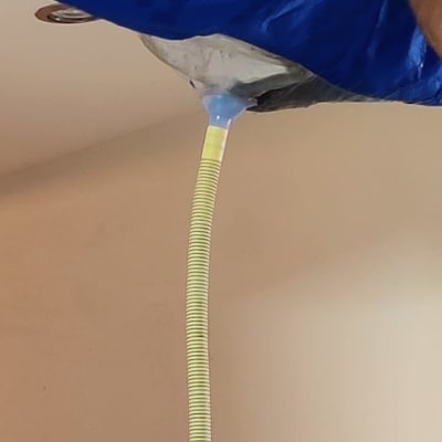 צינור ניקוז מחובר למזגן עם כיסוי כחול