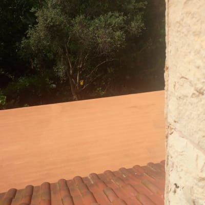 גג רעפים אדום עם קיר אבן בצד ימין