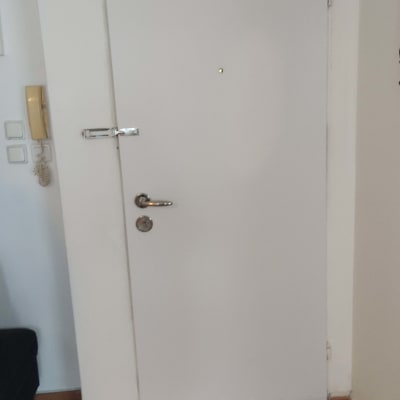 דלת לבנה עם ידית ומנעול כסופים