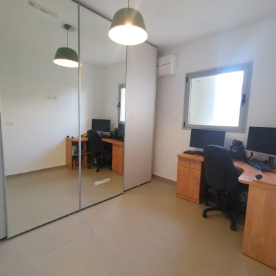 שולחן עבודה עם מחשבים וכיסא משרדי בחדר מסודר