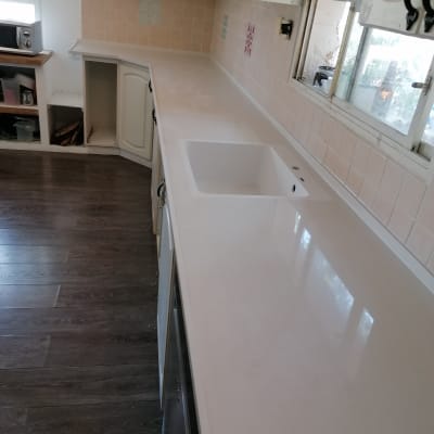 משטח שיש לבן במטבח עם כיור מובנה