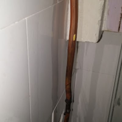 צינור נחושת מותקן על קיר לבן