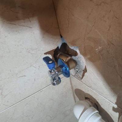 ברז מים עם ידית כחולה וצינור לבן