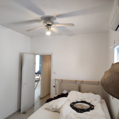 חדר עם קירות צבועים בלבן ומאוורר תקרה