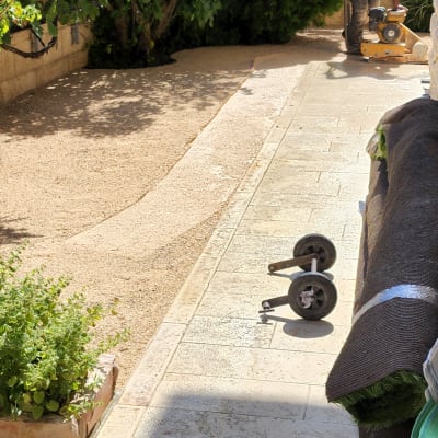 אדם עובד עם מכונה על שביל גינה