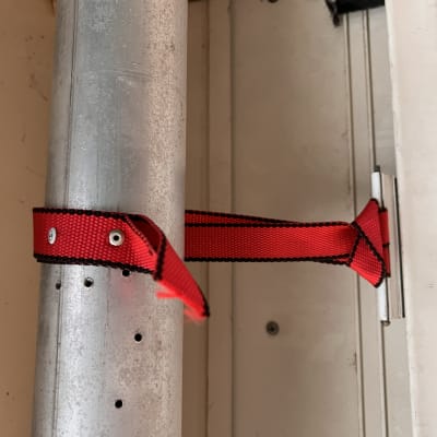 רצועה אדומה מחוברת לתריס מתכת