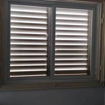 תריסים סגורים על חלון עם מסגרת לבנה