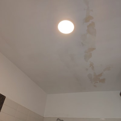 תקרה עם כתמי רטיבות ליד מנורה עגולה