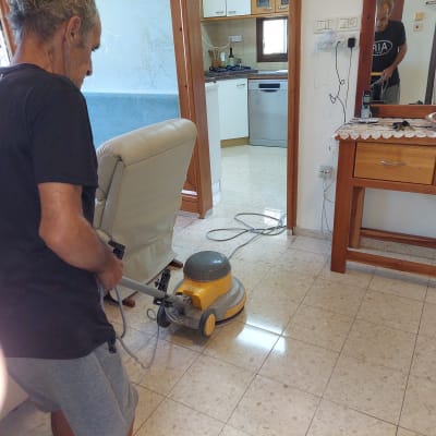 אדם מנקה רצפה עם מכונת פוליש חשמלית