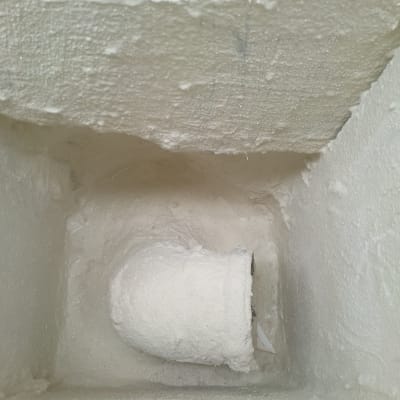 צינור מכוסה בחומר איטום לבן בתוך קיר