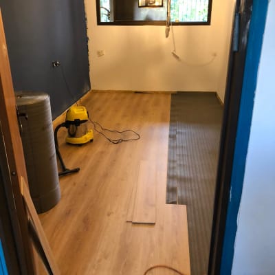 התקנת פרקט עץ בחדר עם קירות לבנים