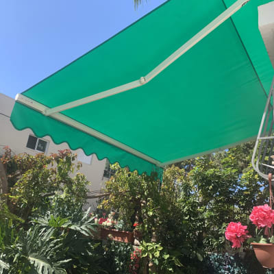 סוכך ירוק עם מסגרת מתכת על קיר חיצוני