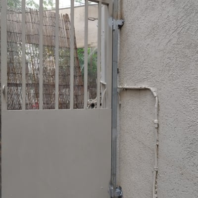 שער מתכת עם מסגרת צמוד לקיר חיצוני