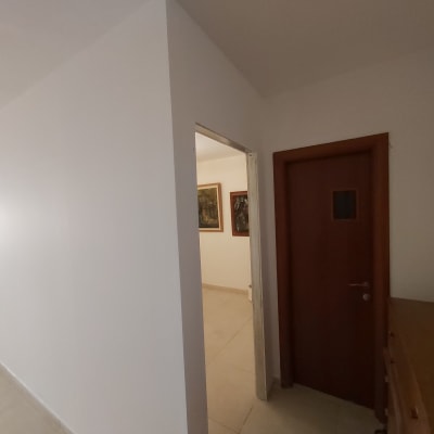 קיר גבס לבן במסדרון עם דלת עץ