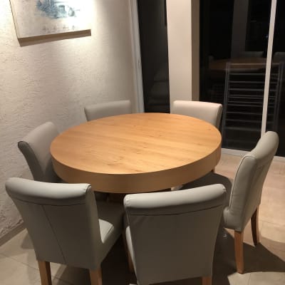 שולחן עגול עם כיסאות מרופדים מסביב