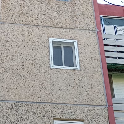 איטום חלון עם מסגרת לבנה על קיר חיצוני