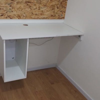 שולחן עבודה לבן עם חור לכבלים על רקע עץ