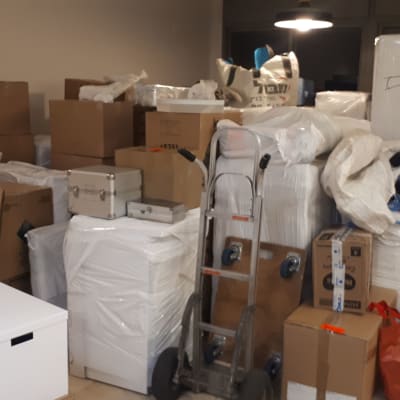 ארגזים וציוד ארוזים למעבר דירה עם עגלת משא