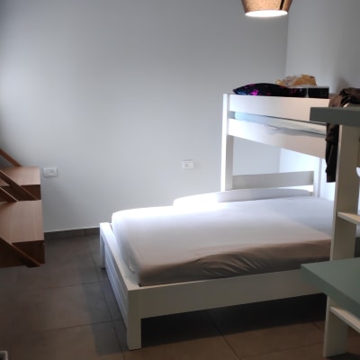 חדר עם מיטת קומותיים וקיר צבוע בלבן