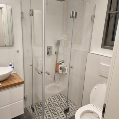 מקלחון זכוכית עם ראש מקלחת ומוצרי טיפוח