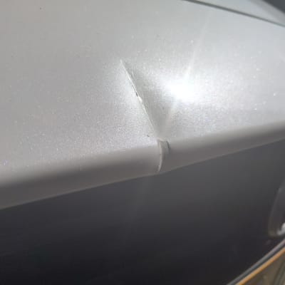 נזק קל בפח רכב בצבע לבן