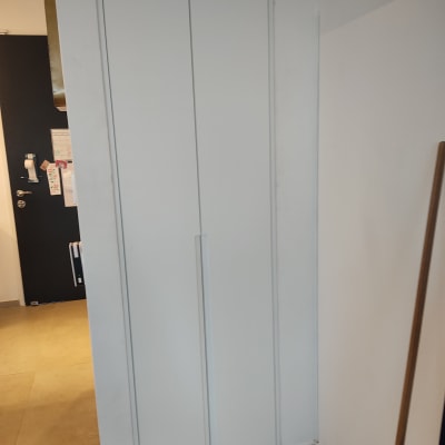 ארון לבן עם דלתות סגורות ומוט עץ בצד