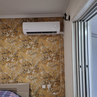 מזגן מותקן על קיר עם טפט פרחוני