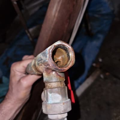 צינור מתכת עם חלודה ושסתום אדום