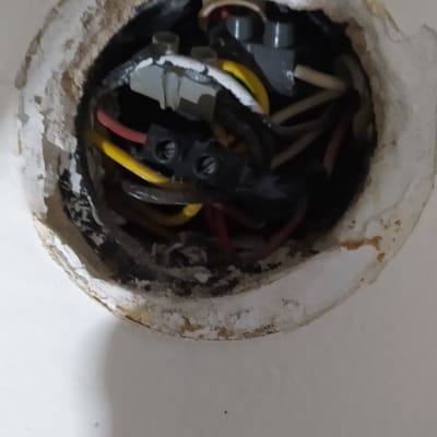 חוטי חשמל צבעוניים מחוברים בקופסת חיבורים בקיר