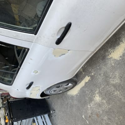 רכב לבן עם תיקוני פחחות בצבע ובחומר מילוי