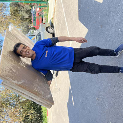 אדם נושא לוחות עץ עטופים בניילון