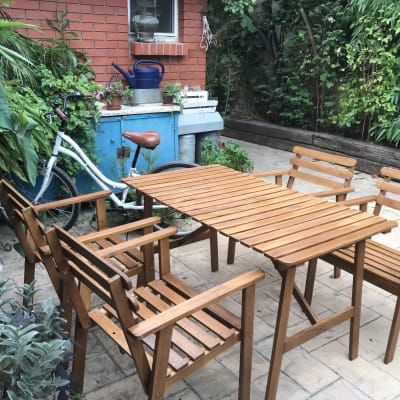 ריהוט גן מעץ עם שולחן וכיסאות בחצר