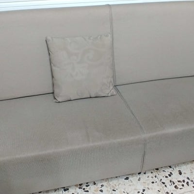 ספה עם כרית דקורטיבית על רצפת אריחים