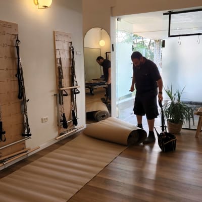 אדם עם תיק כלים עומד על רצפה בחדר מואר