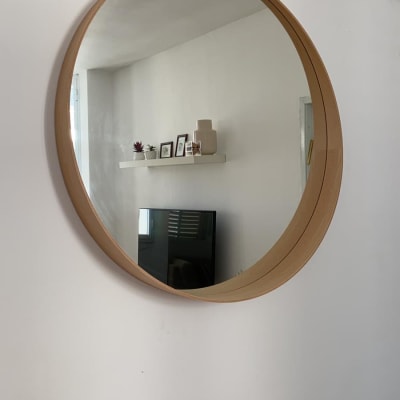 מראה עגולה תלויה על קיר לבן