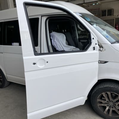 דלת רכב לבנה פתוחה בתהליך תיקון