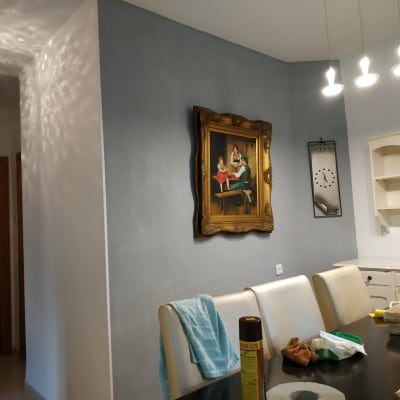 A framed painting on a wall in a dining room.