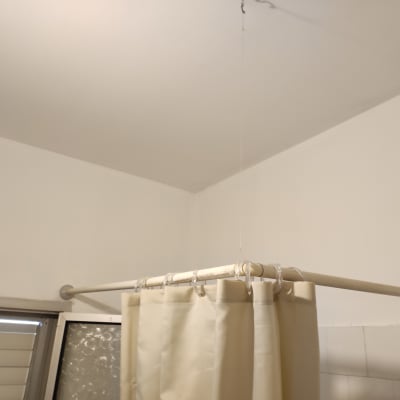 קיר צבוע בלבן עם וילון מקלחת