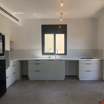 מטבח משופץ עם ארונות לבנים וכיור חדש