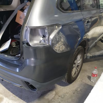 רכב אפור עם פגוש אחורי חסר ופנס מפורק