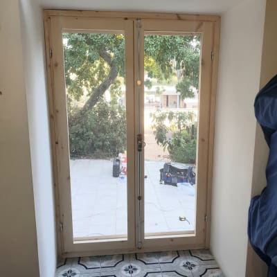 דלת זכוכית כפולה עם מסגרת עץ בהירה