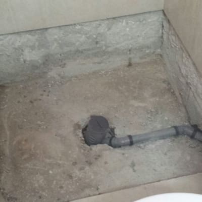 צינור ביוב חשוף ברצפת חדר אמבטיה בשיפוץ