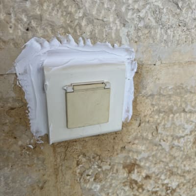 שקע חשמלי עם טיח לבן על קיר