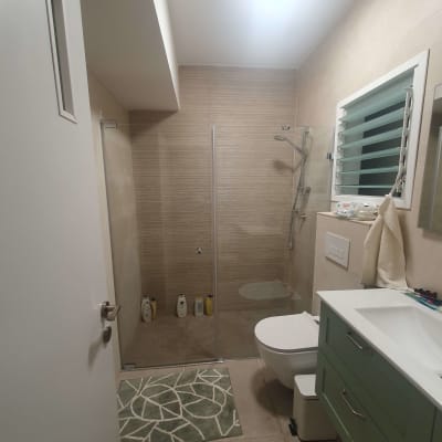 חדר אמבטיה משופץ עם מקלחון, כיור ושירותים מודרניים