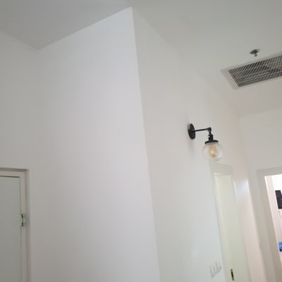 קיר צבוע בלבן עם מנורה על הקיר