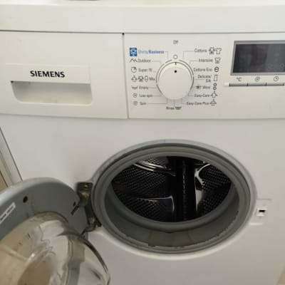 מכונת כביסה פתוחה עם לוח בקרה ותוכניות כביסה