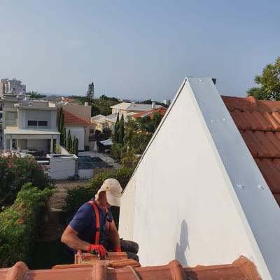 אדם עובד על גג רעפים עם חבל בטיחות