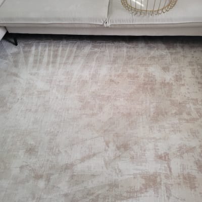 ספה אפורה עם כריות על שטיח בהיר